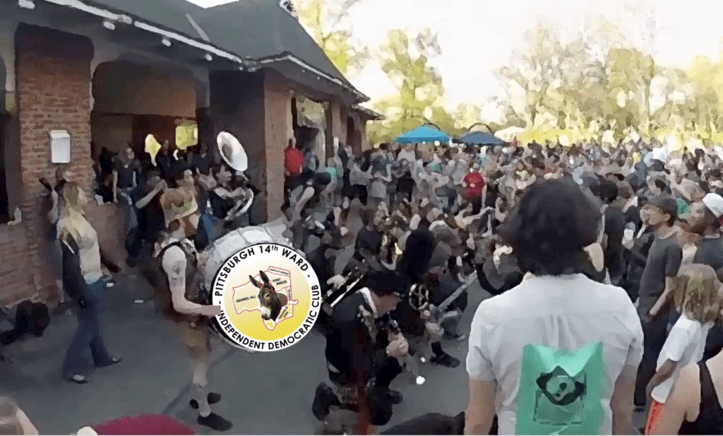 A big crowd at theVietnam Veterans Pavilion in Schenley Park, with the Pittsburgh 14th Ward Independent Democratic Club logo on a bass drum in the foreground.